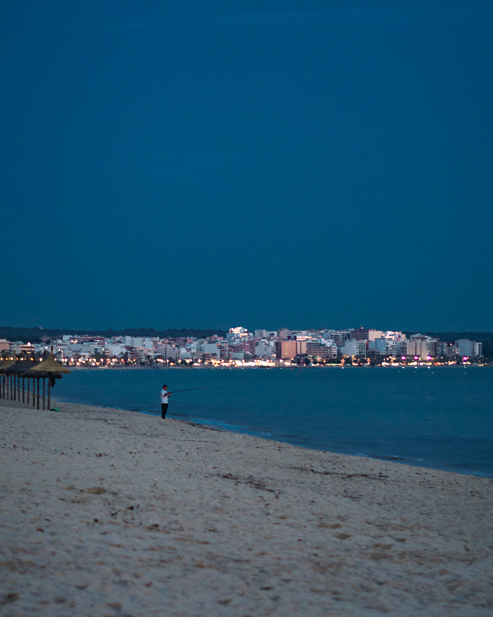 evening beach with city lights in the background