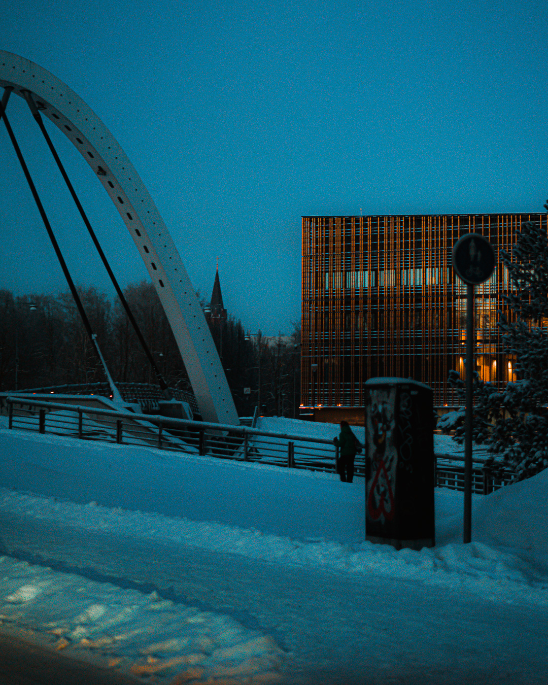 modern university building in the background of a snowy road