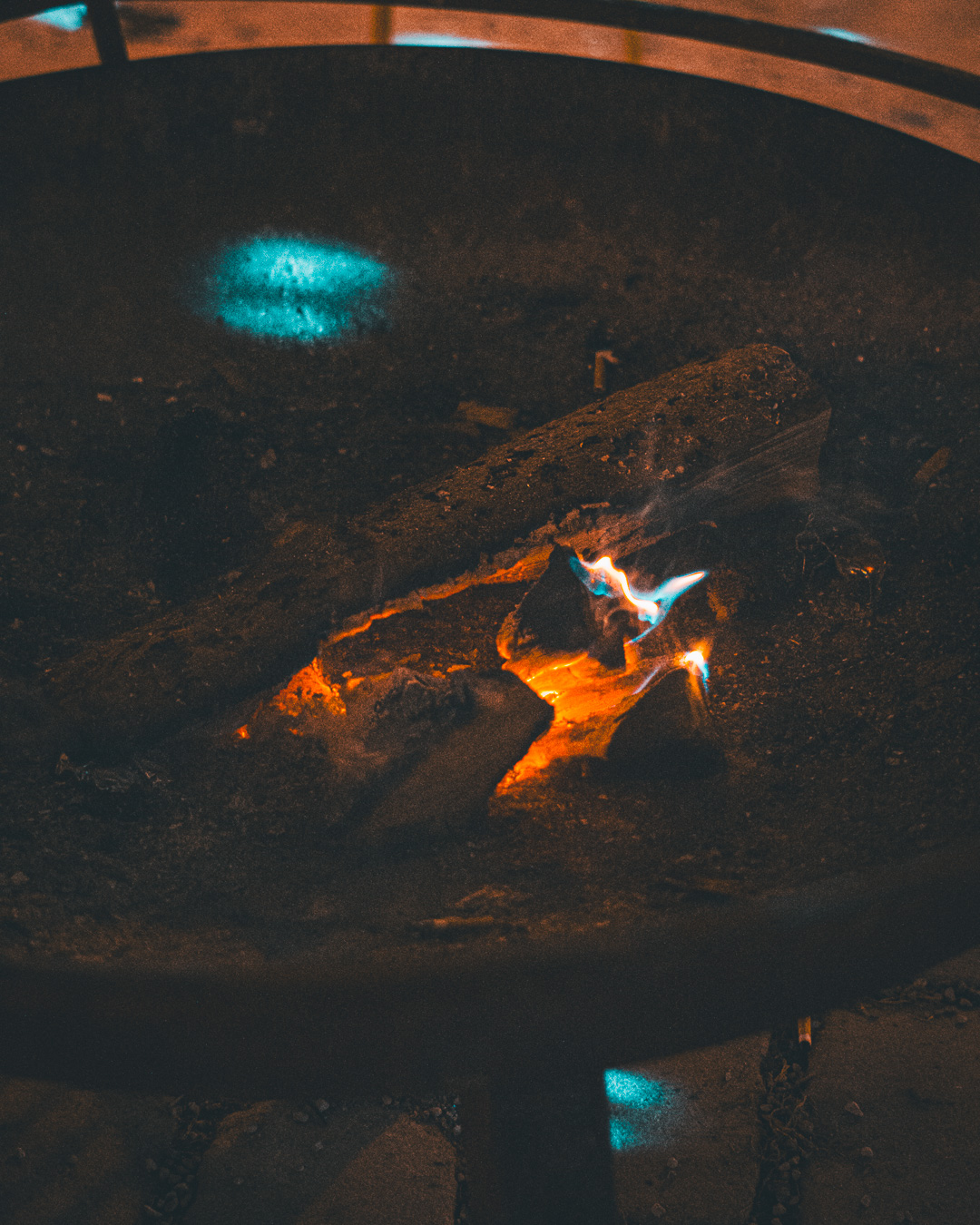 close up of a fading flame in a firepit at night