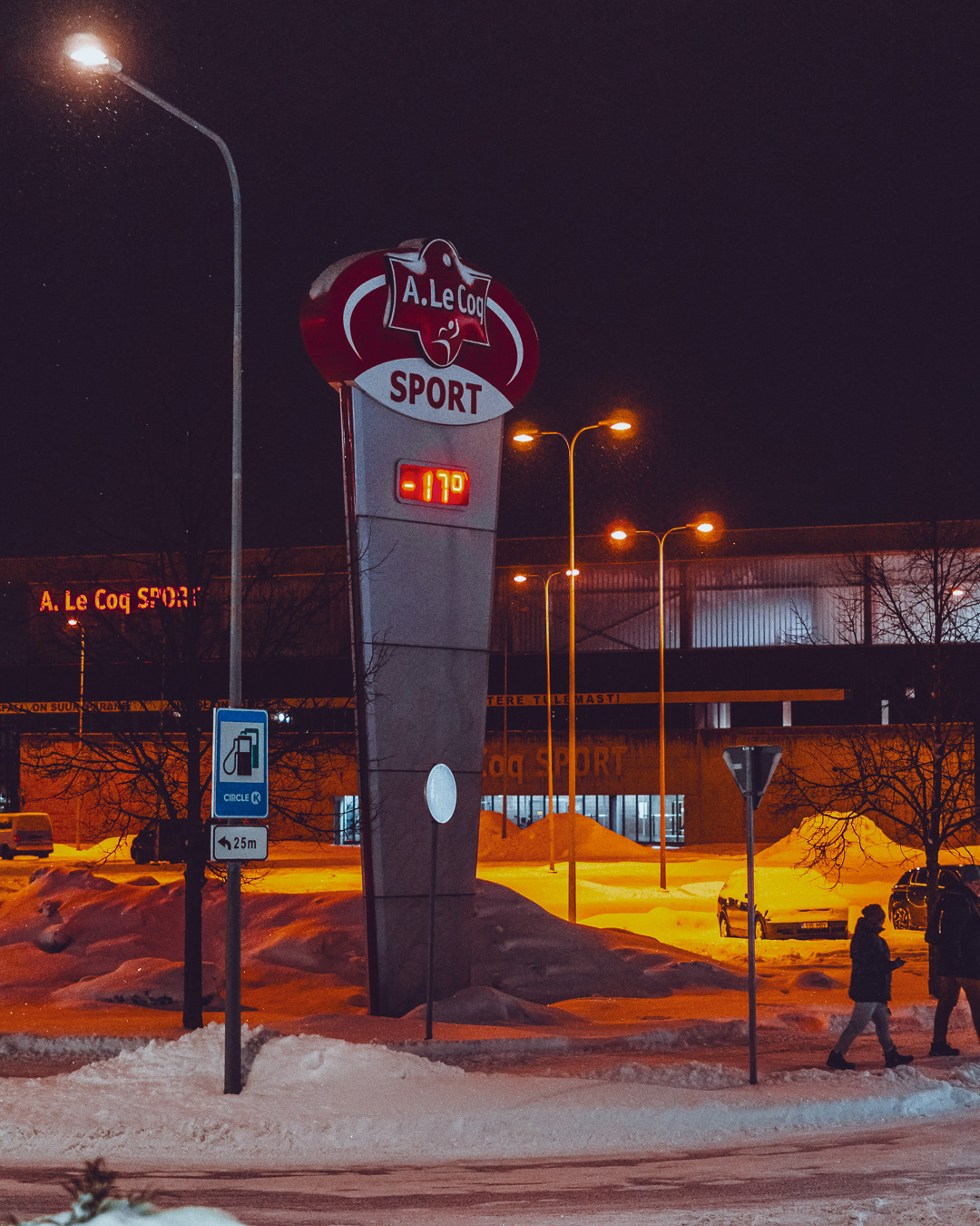 A le coq stadium in the background of a snowy road