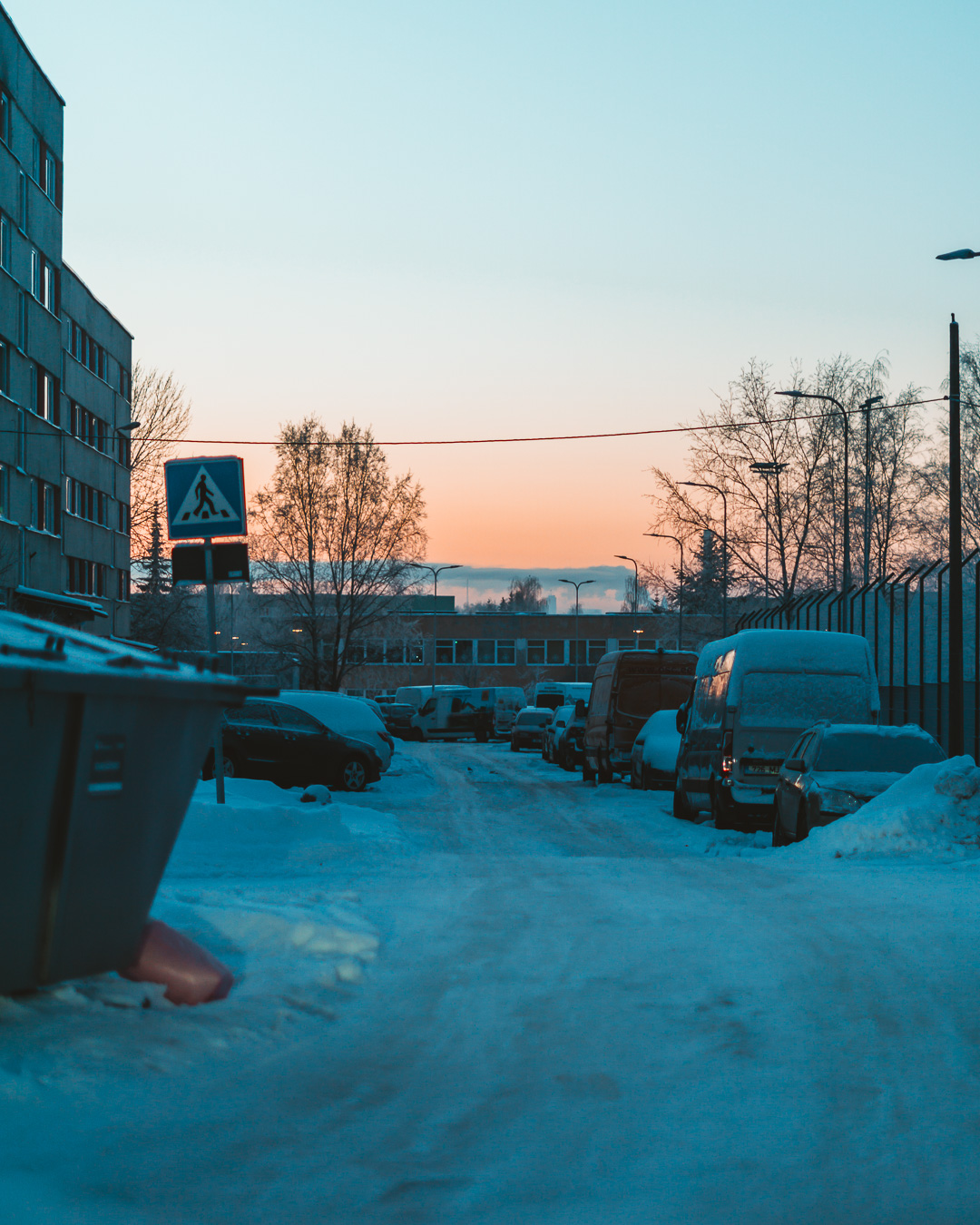 sunset on a snowy road in a residential area